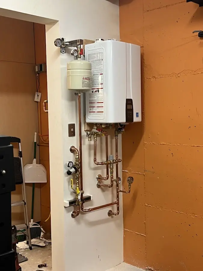 Plumbing technician inspecting water heater connections in Grove